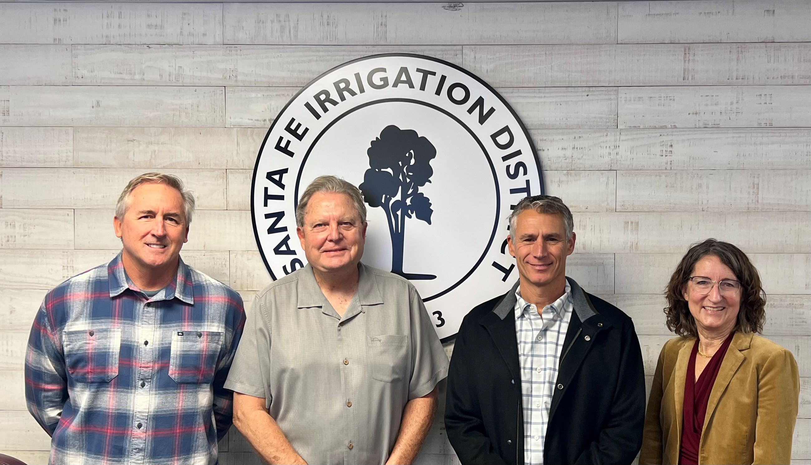 Four board members standing in front of the SFID sign 